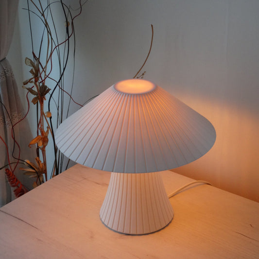 Table lamp with a soft glow on a light-colored wall.